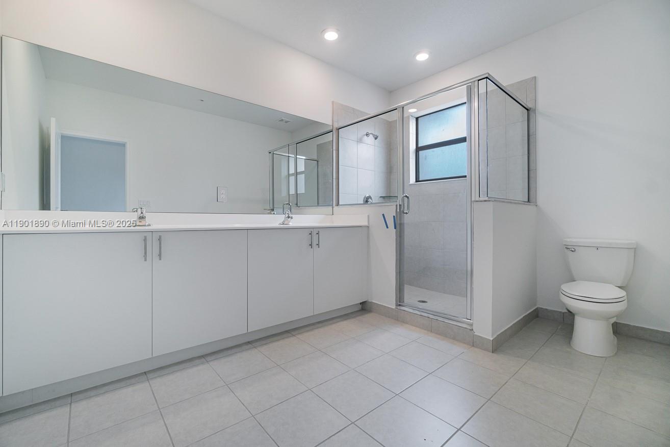 207 Southwest 159th Terrace Pembroke Pines, FL 33027 - Photo 33 of 37 a bathroom with a toilet sink and mirror