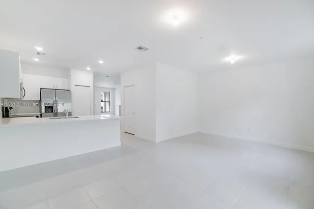 a view of kitchen with refrigerator and window