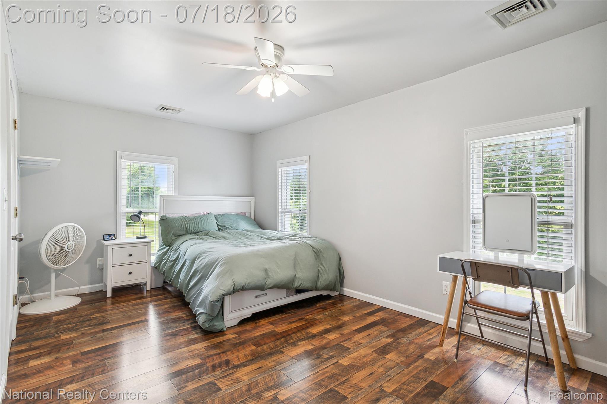 9589 Clinton Macon Road Tecumseh, MI 49286 - Photo 29 of 48 Wood-finish flooring throughout, featuring a ceiling fan with integrated lighting, multiple windows with blinds, and white painted walls