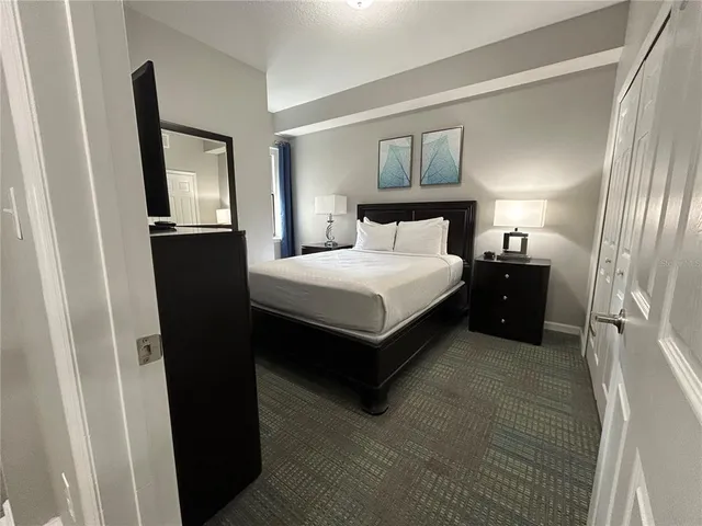 a bedroom with a bed and a flat screen tv