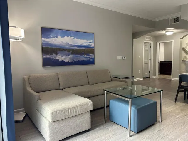 a large living room with stainless steel appliances granite countertop couches a fireplace and a large window