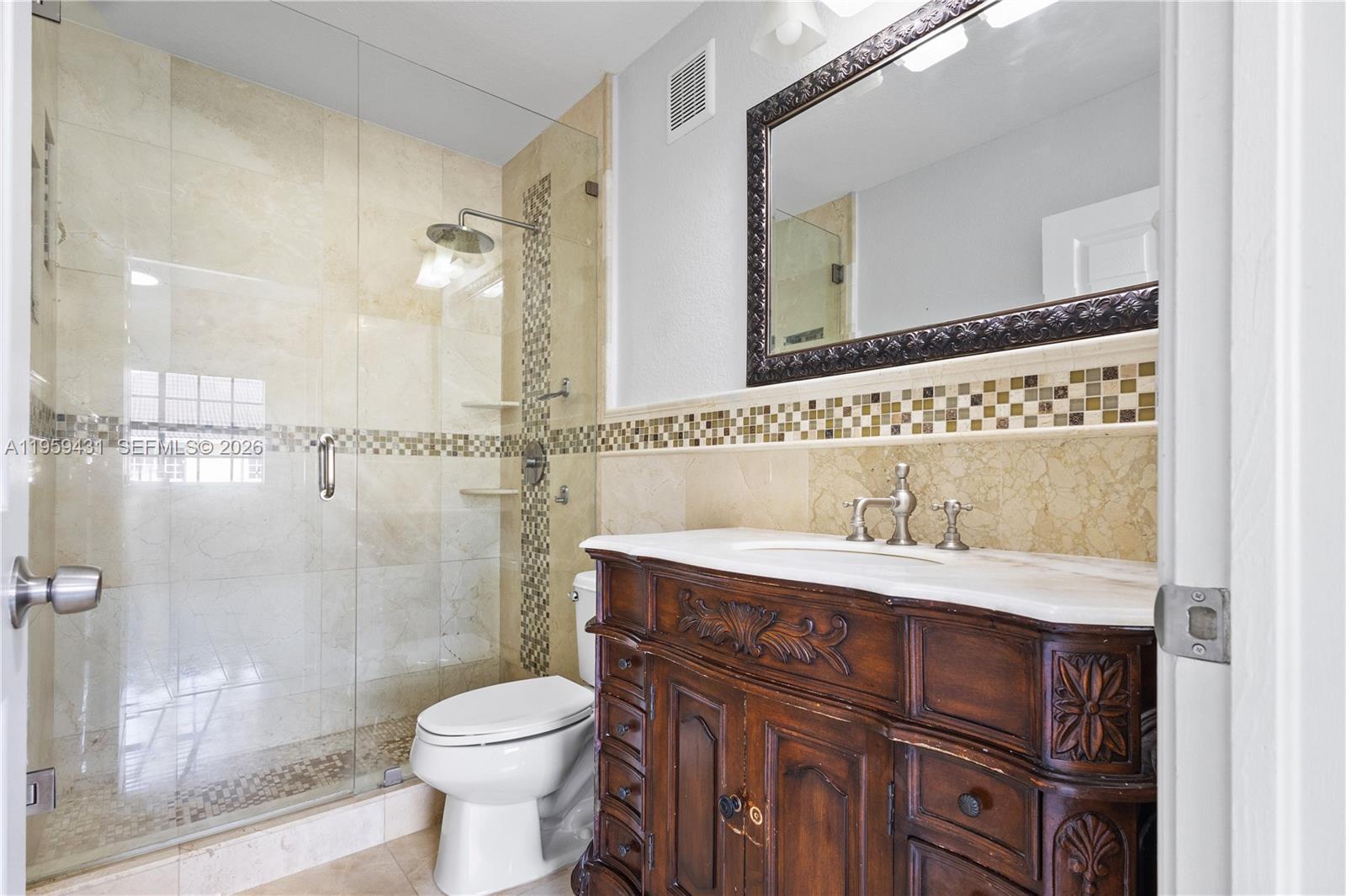 6765 Northwest 182nd Street, Unit 104 Hialeah, FL 33015 - Photo 13 of 24 a bathroom with a sink vanity mirror and toilet