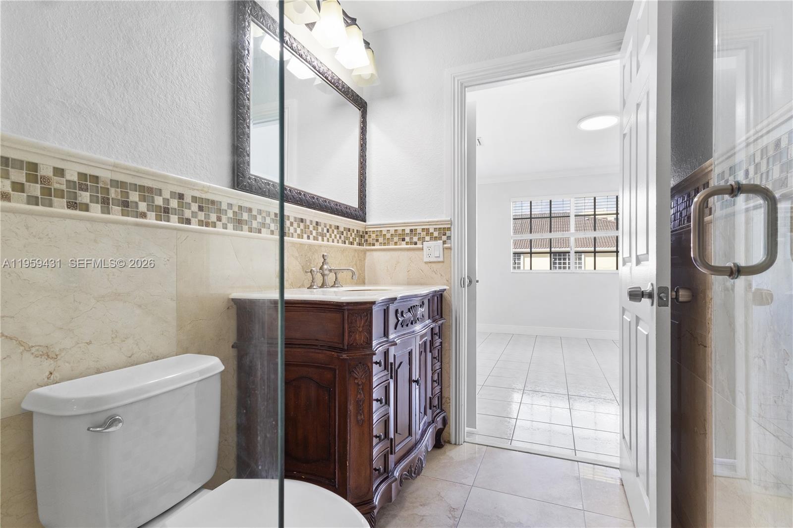 6765 Northwest 182nd Street, Unit 104 Hialeah, FL 33015 - Photo 16 of 24 a bathroom with a toilet a sink and a mirror