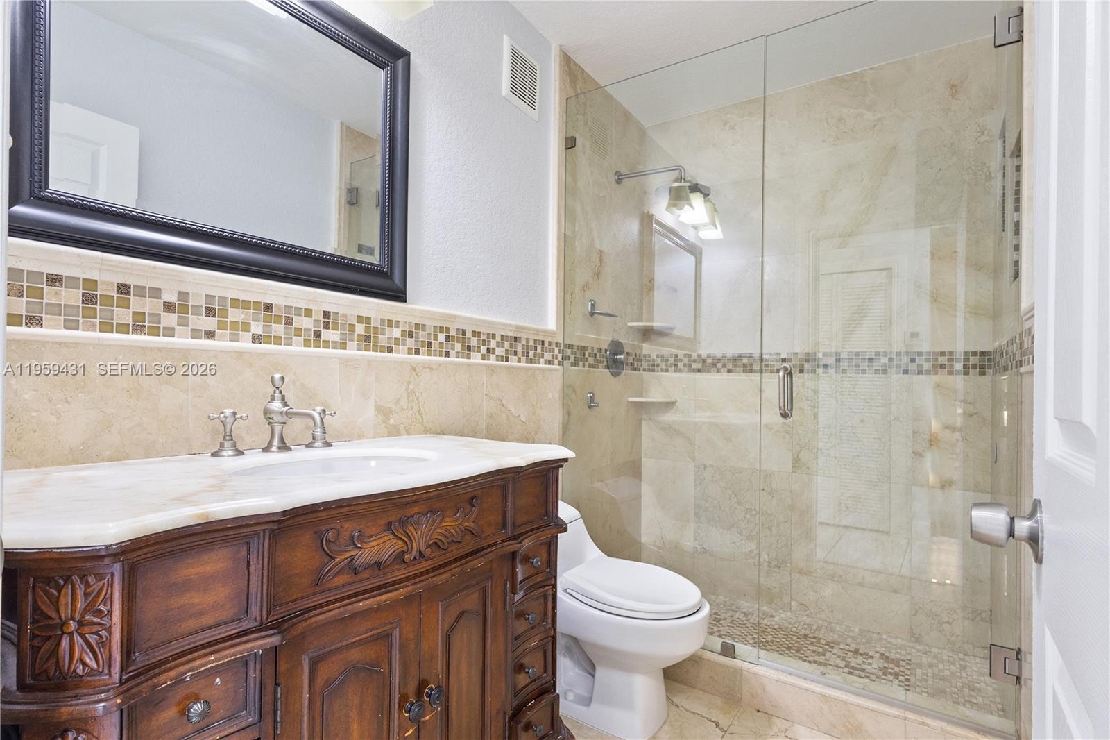 6765 Northwest 182nd Street, Unit 104 Hialeah, FL 33015 - Photo 19 of 24 a bathroom with a sink a toilet and a mirror