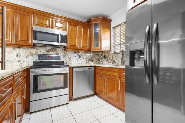 a kitchen with stainless steel appliances granite countertop a refrigerator stove and sink