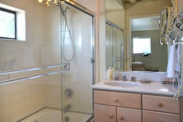 a bathroom with a double vanity sink mirror and shower