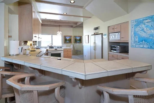 a kitchen with a table chairs and refrigerator