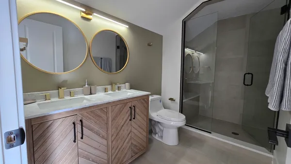 a bathroom with a sink mirror toilet and shower