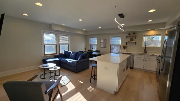 a living room with a couch and a refrigerator