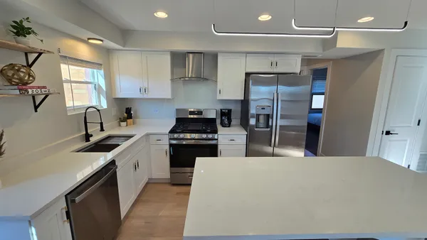 a kitchen with stainless steel appliances granite countertop a sink stove and refrigerator