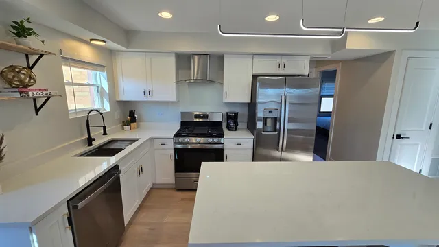 a kitchen with stainless steel appliances granite countertop a sink stove and refrigerator