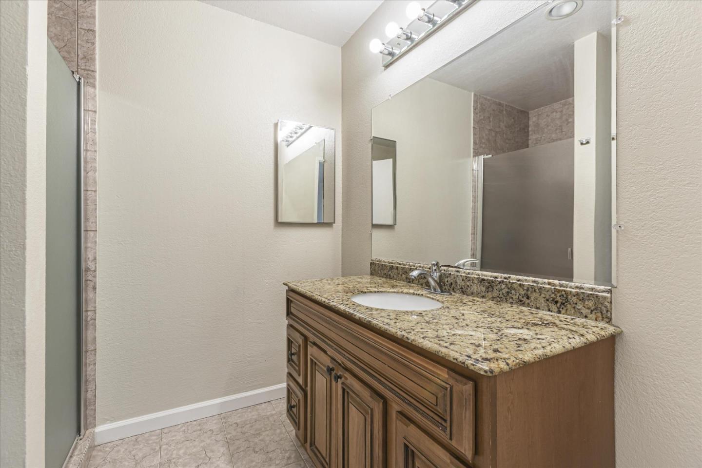 4260 Clayton Road, Unit 20 Concord, CA 94521 - Photo 16 of 35 a bathroom with a granite countertop sink and a mirror