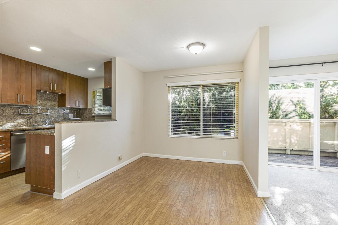4260 Clayton Road, Unit 20 Concord, CA 94521 - Photo 6 of 35 a kitchen with stainless steel appliances granite countertop a refrigerator a sink a stove and white cabinets with wooden floor next to windows