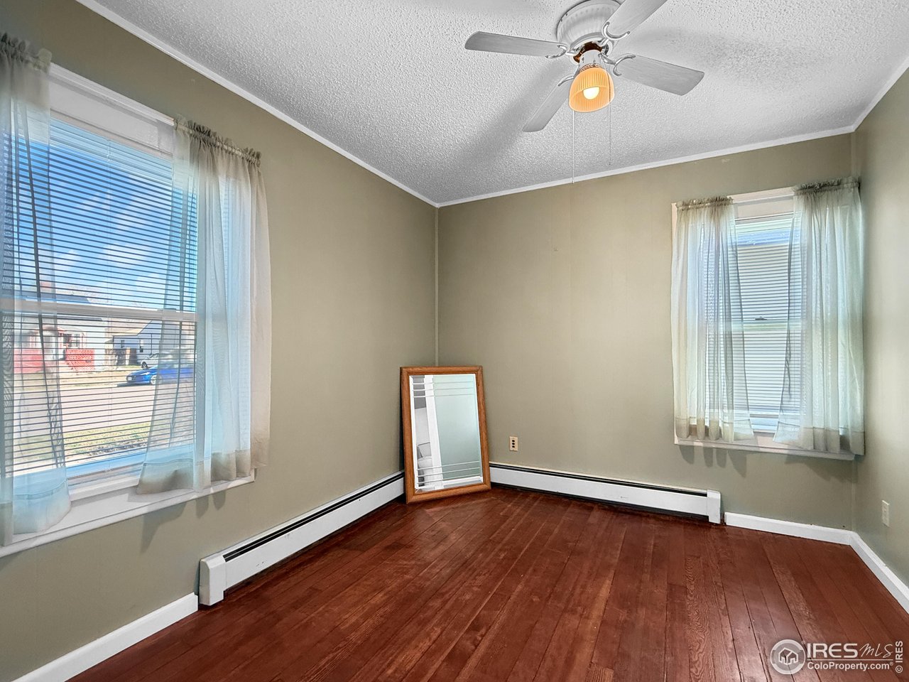 531 Taylor Street Sterling, CO 80751 - Photo 9 of 38 an empty room with wooden floor and windows