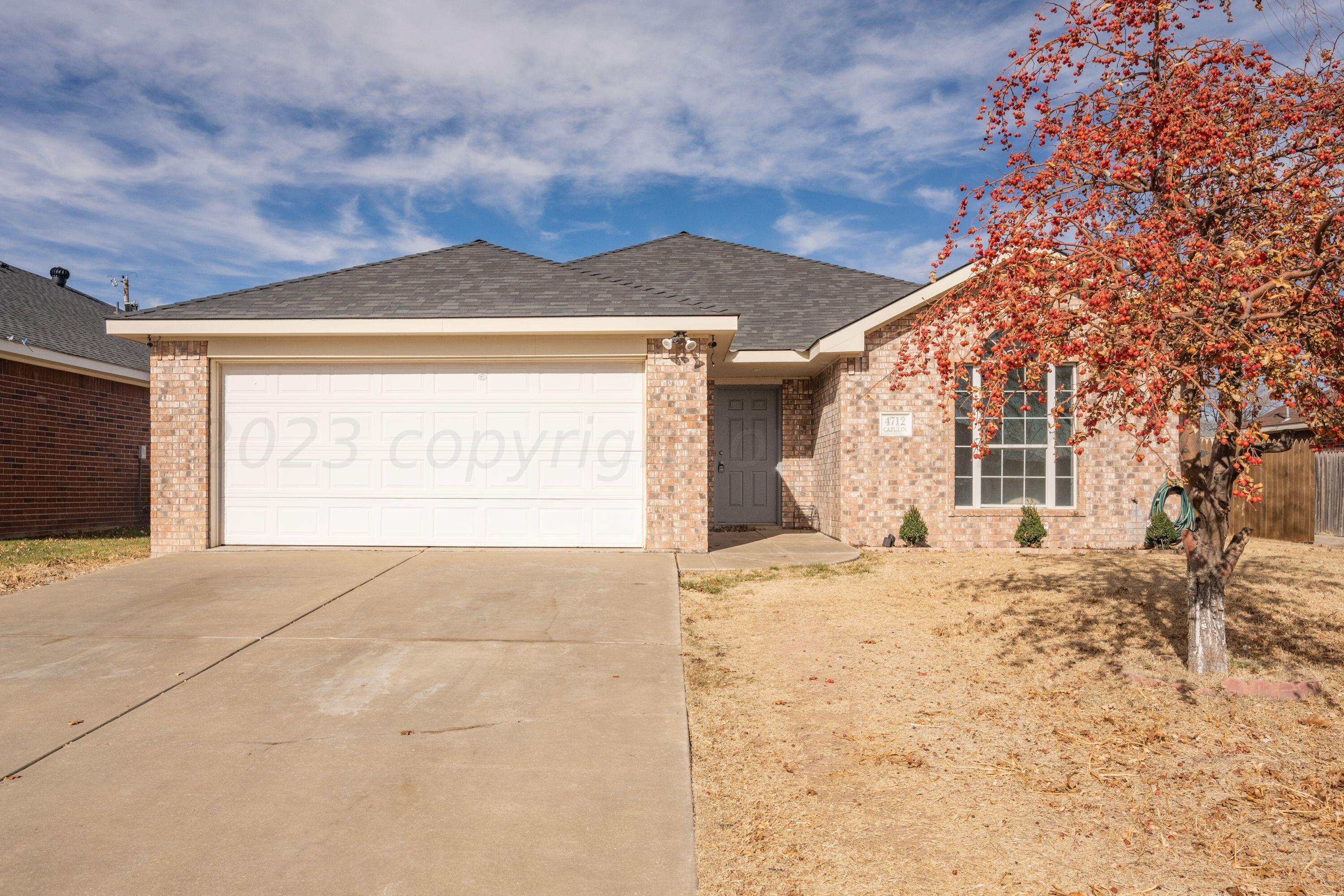 4712 Capulin Lane Amarillo, TX 79110 - Photo 1 of 18 a front view of a house with a yard and garage