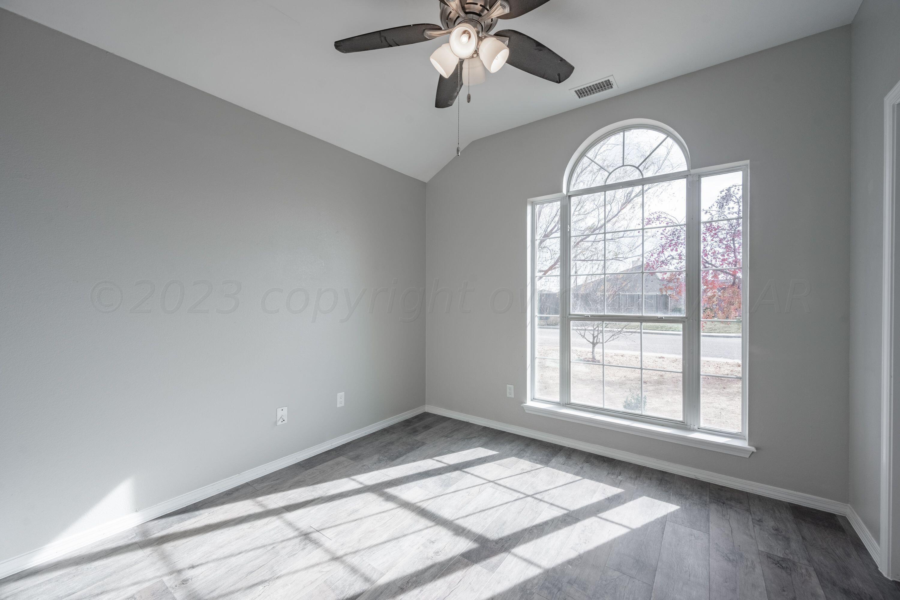 4712 Capulin Lane Amarillo, TX 79110 - Photo 11 of 18 an empty room with windows and chandelier fan