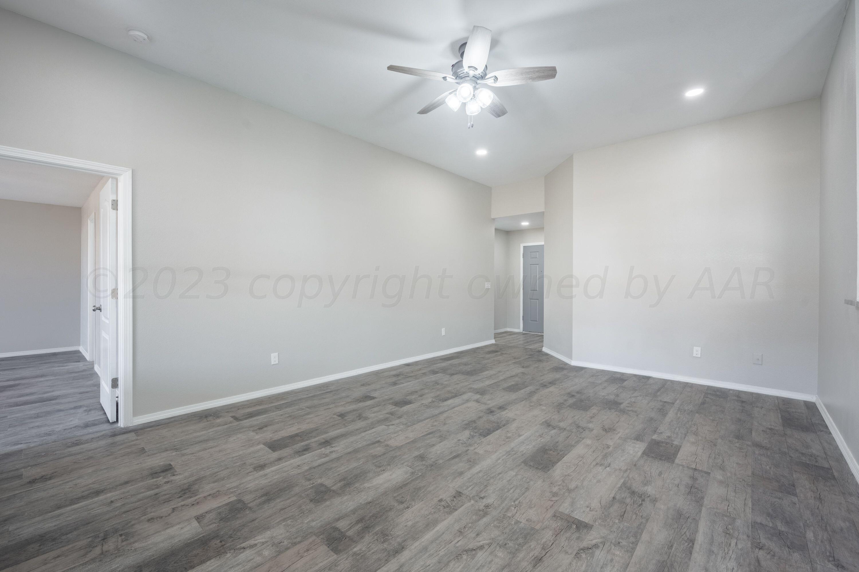 4712 Capulin Lane Amarillo, TX 79110 - Photo 12 of 18 wooden floor in an empty room with a window