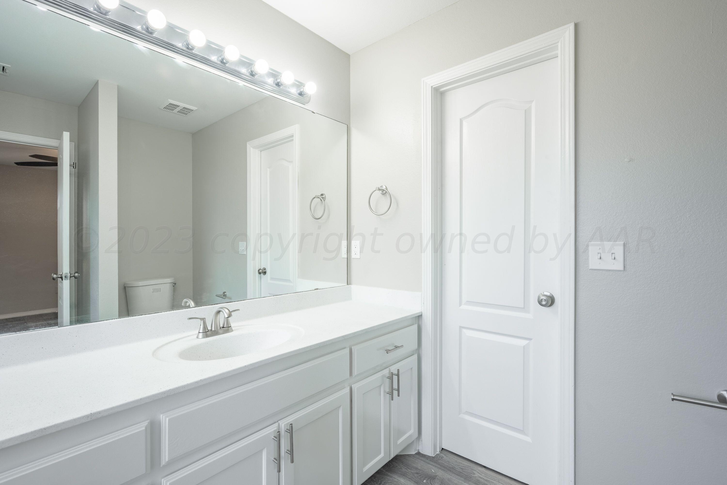 4712 Capulin Lane Amarillo, TX 79110 - Photo 13 of 18 a bathroom with a sink and a mirror