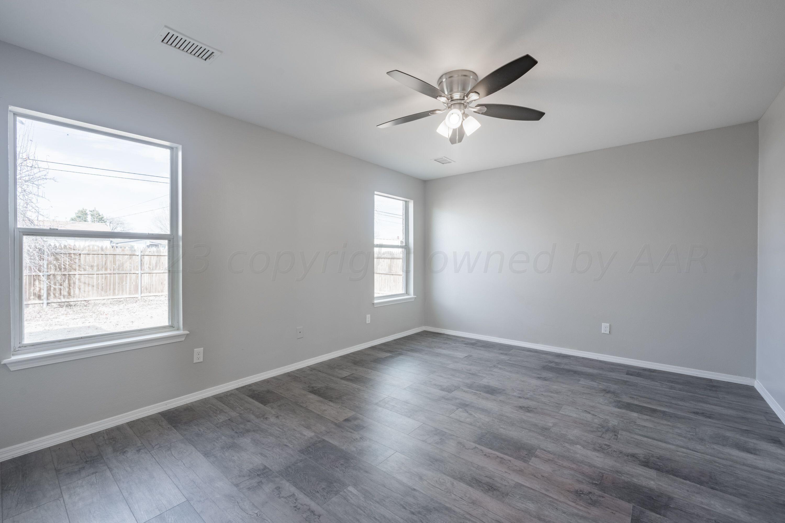 4712 Capulin Lane Amarillo, TX 79110 - Photo 16 of 18 a view of an empty room with wooden floor and a window