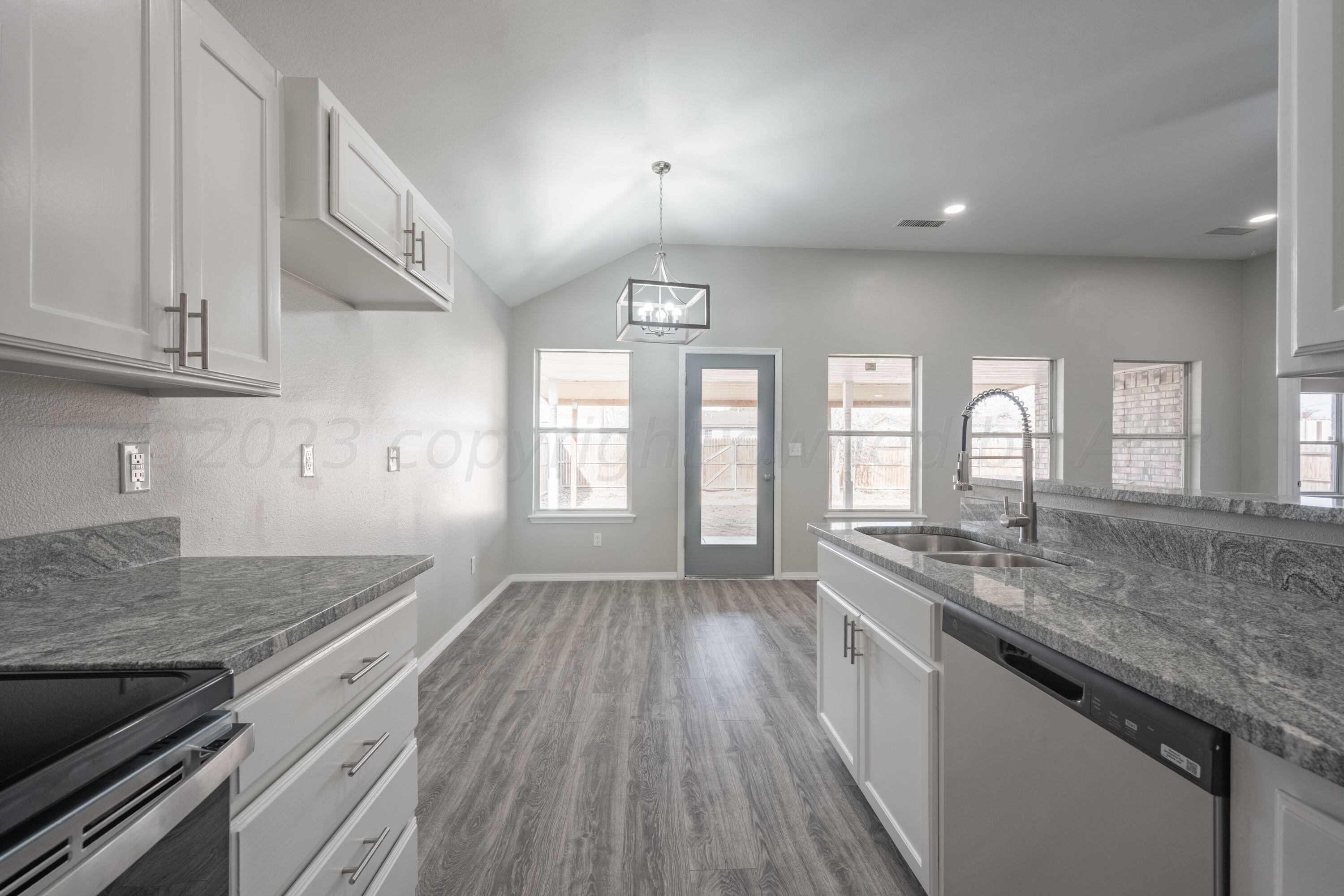 4712 Capulin Lane Amarillo, TX 79110 - Photo 4 of 18 a kitchen with granite countertop a stove and a sink