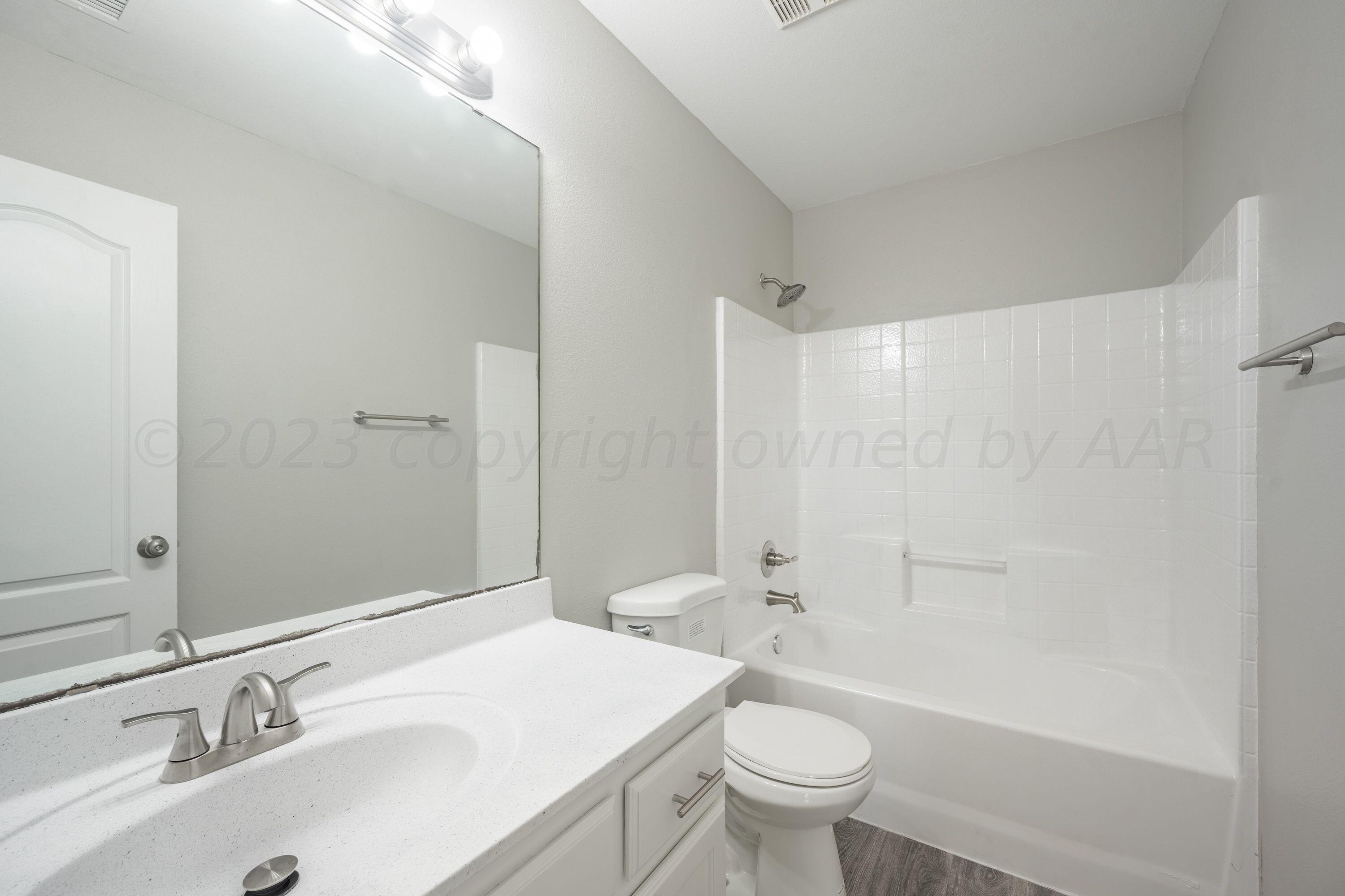 4712 Capulin Lane Amarillo, TX 79110 - Photo 9 of 18 a bathroom with a sink toilet vanity and shower