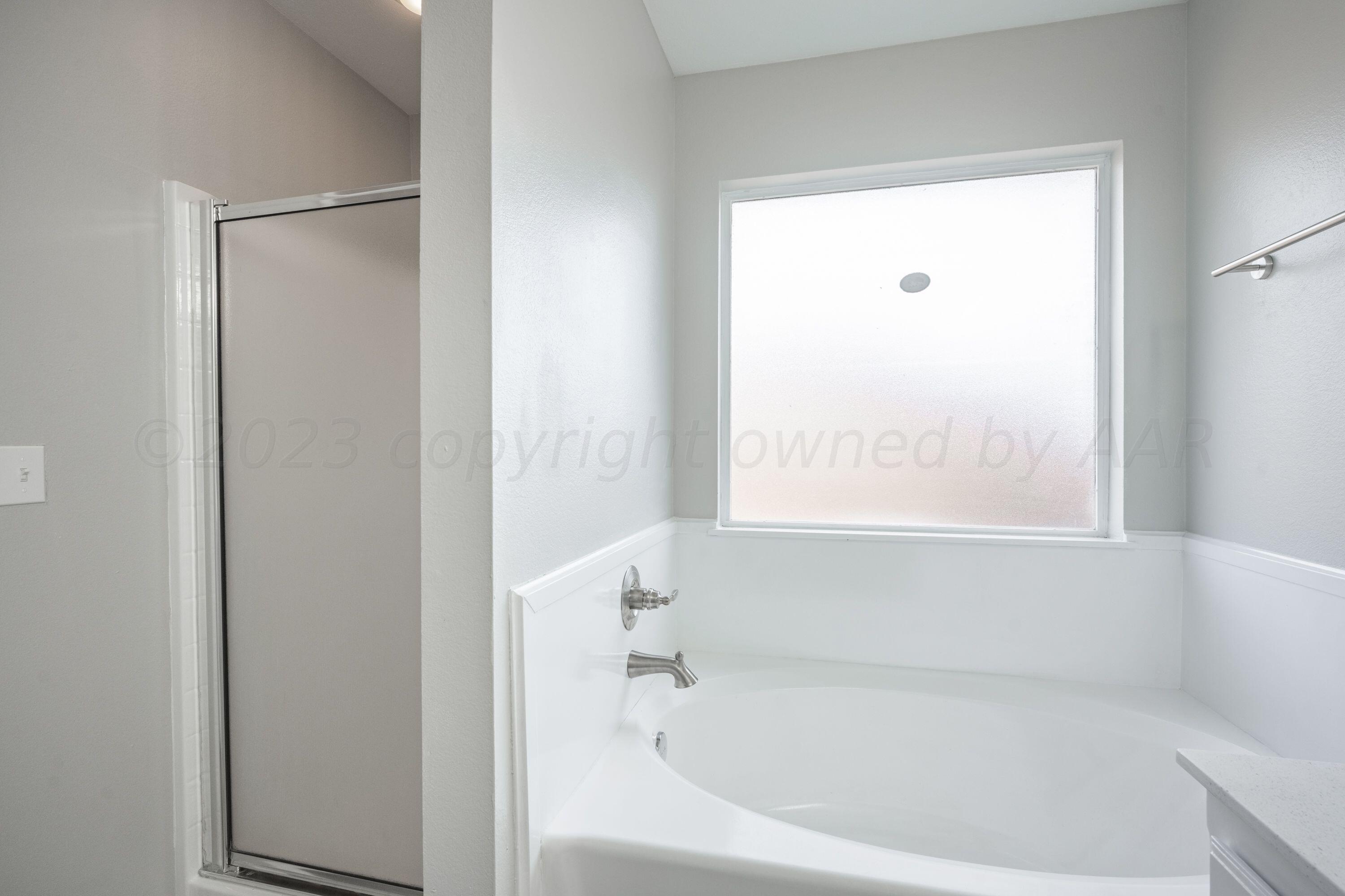 4712 Capulin Lane Amarillo, TX 79110 - Photo 10 of 18 a white bath tub with a shower