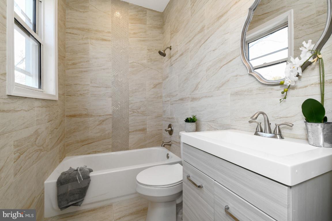 3815 Chatham Road Baltimore, MD 21215 - Photo 21 of 28 a bathroom with a sink a toilet and a mirror