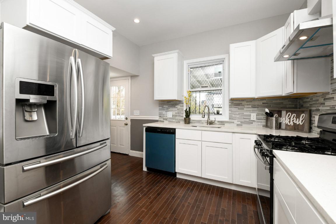 3815 Chatham Road Baltimore, MD 21215 - Photo 24 of 28 a kitchen with a refrigerator stainless steel appliances wooden floor and cabinets