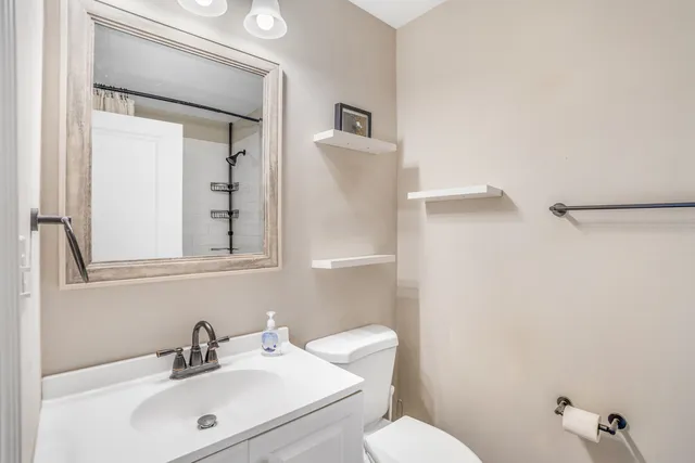 a bathroom with a sink mirror and toilet