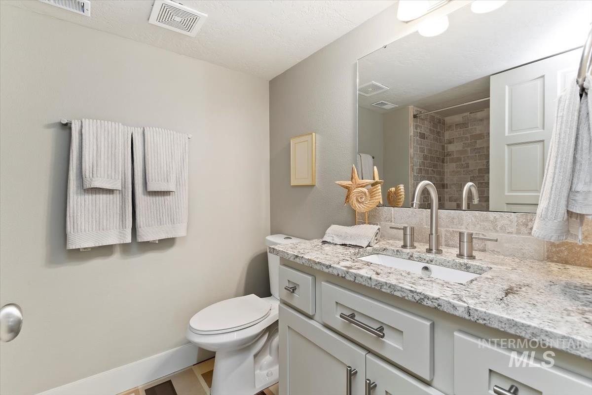 709 East Braemere Road Boise, ID 83702 - Photo 29 of 50 Light-toned vanity with integrated sink, brushed nickel faucet, stone countertop, and large wall-mounted mirror