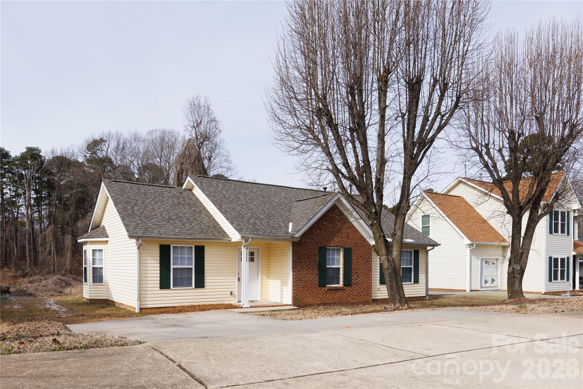 a front view of a house with a yard and trees