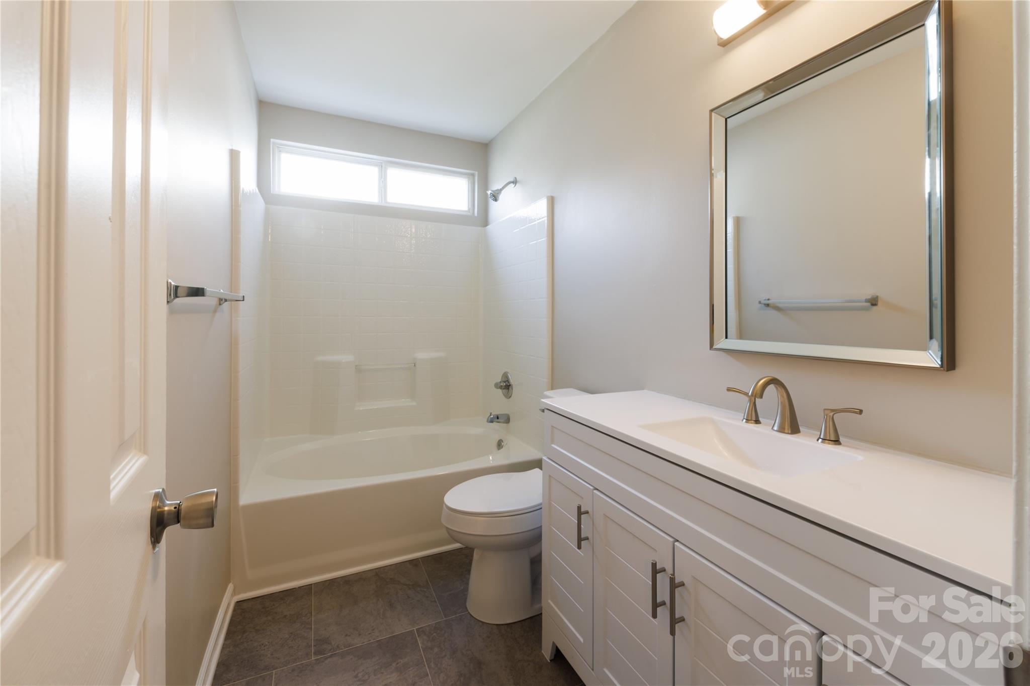 7111 Rumple Road Charlotte, NC 28262 - Photo 13 of 18 a bathroom with a bathtub shower sink vanity mirror and toilet