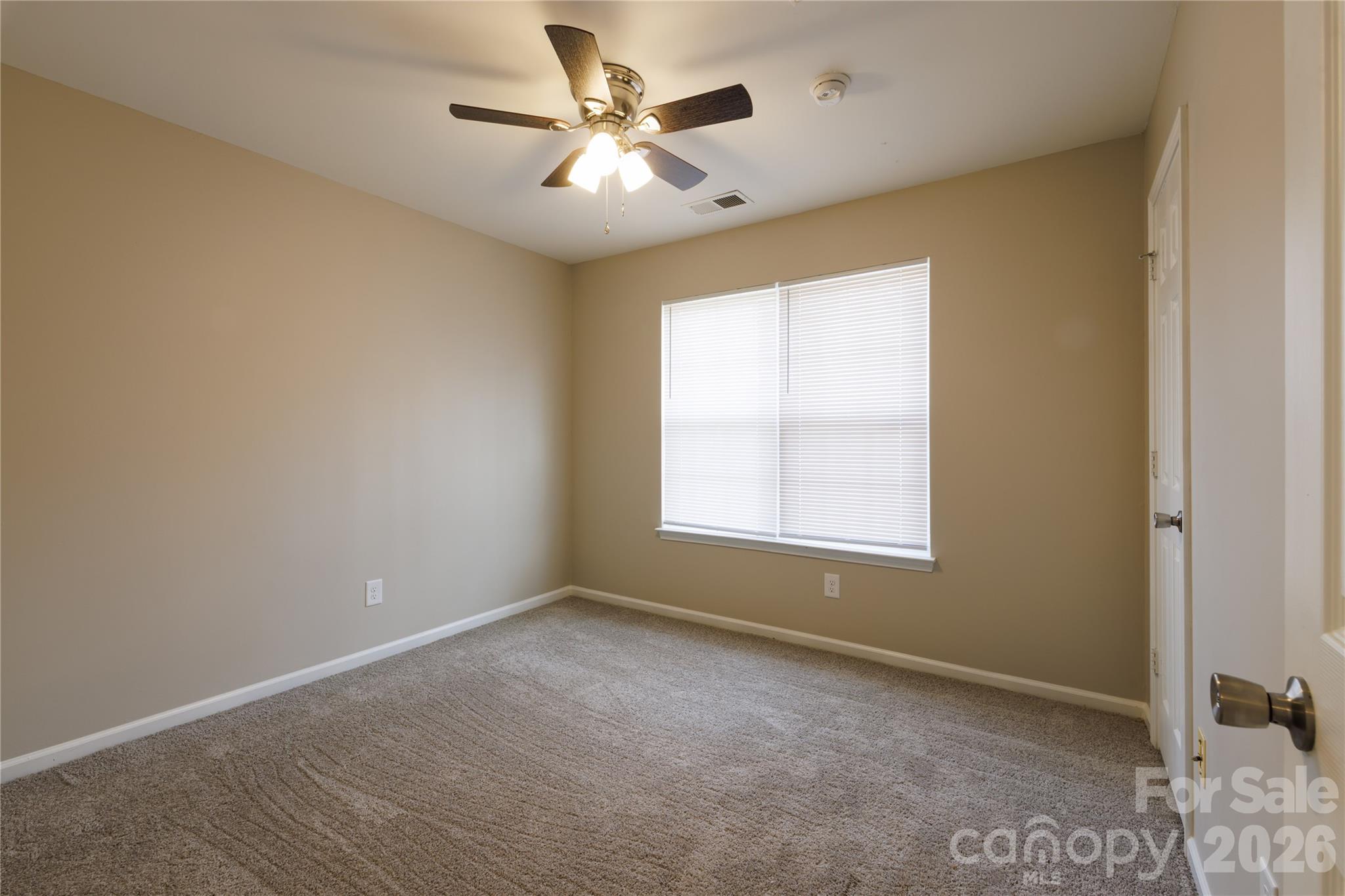 7111 Rumple Road Charlotte, NC 28262 - Photo 14 of 18 an empty room with a chandelier fan and windows