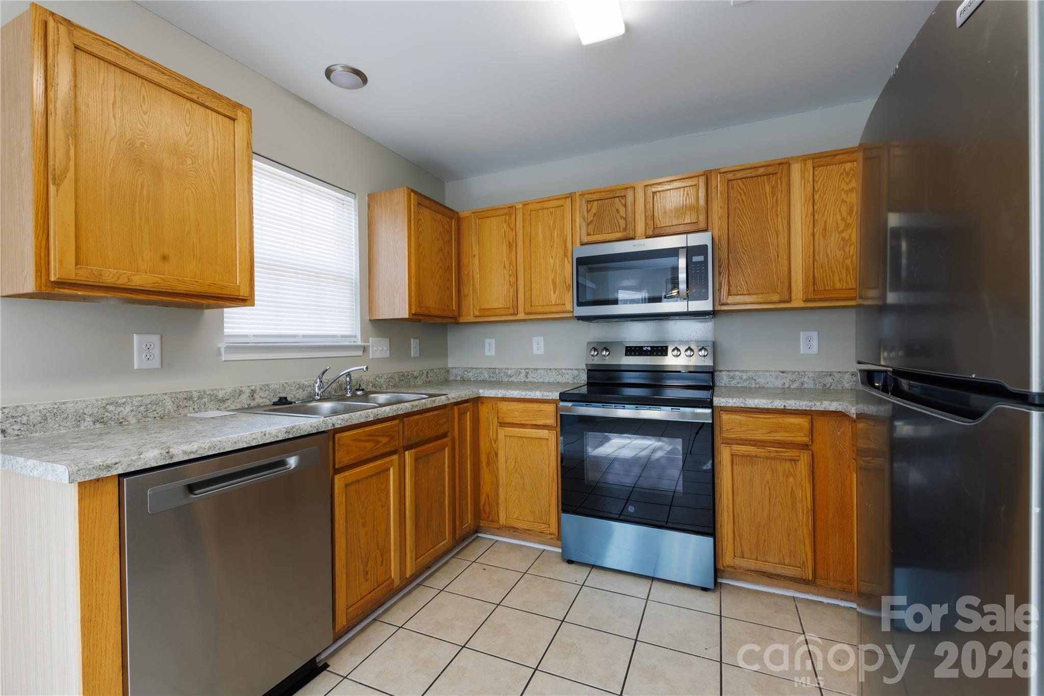 7111 Rumple Road Charlotte, NC 28262 - Photo 5 of 18 a kitchen with stainless steel appliances granite countertop wooden cabinets a stove top oven a sink and dishwasher