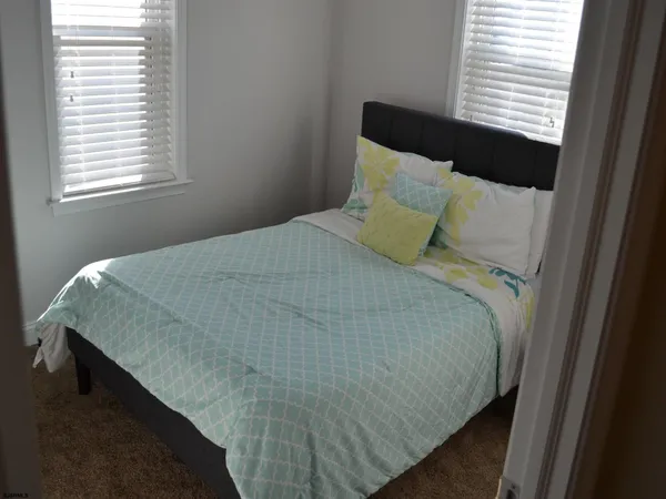 a bed sitting in a bedroom next to a window