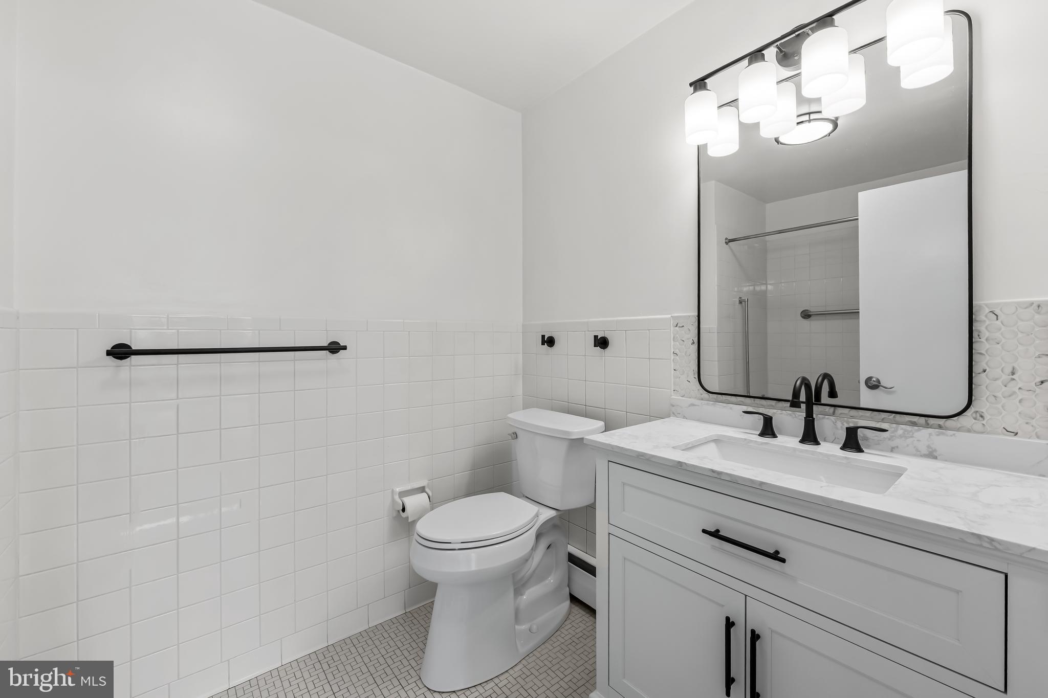 11 Slade Avenue, Unit 911 Baltimore, MD 21208 - Photo 23 of 32 a bathroom with a sink vanity mirror and toilet