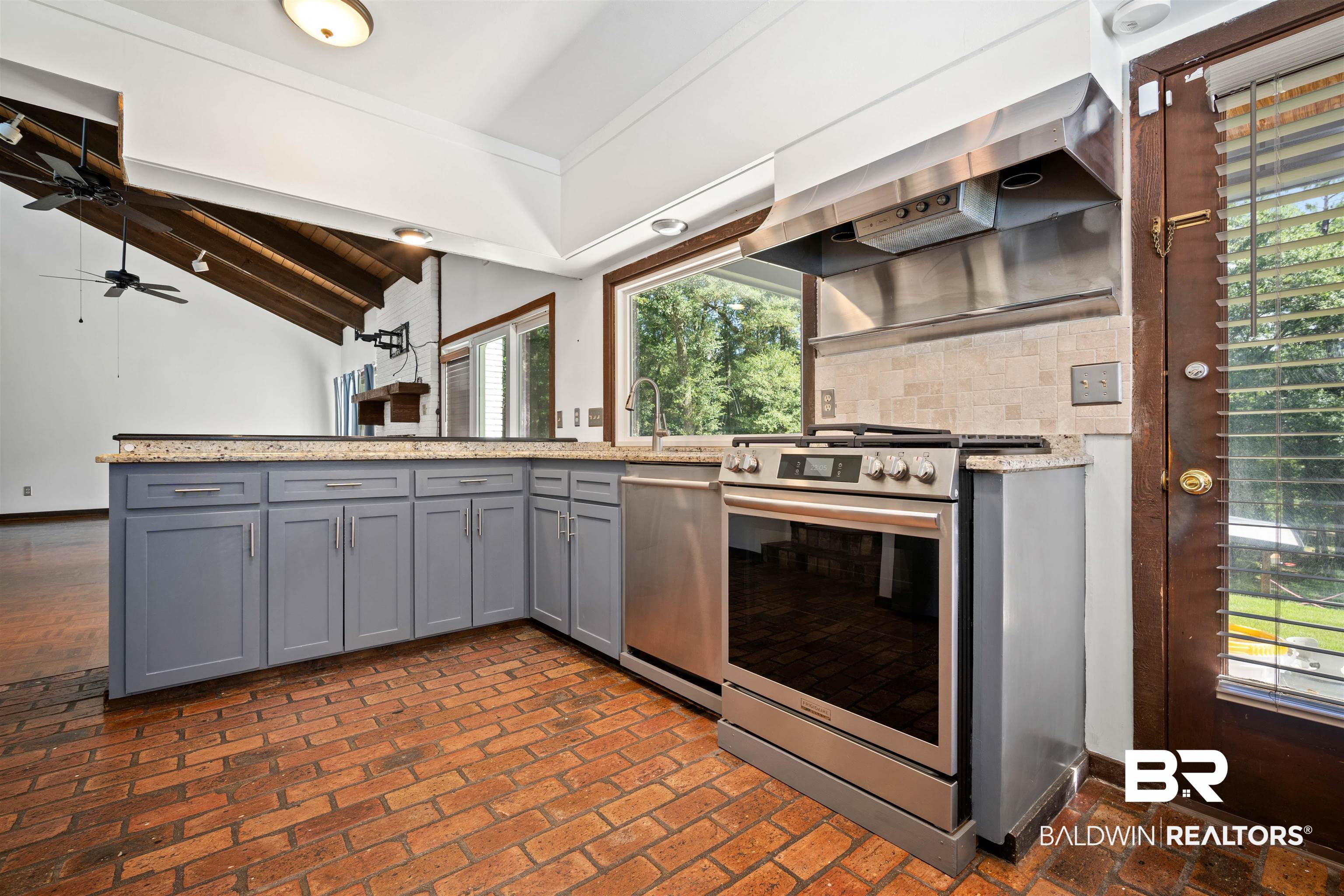 7912 Yorkhaven Road Mobile, AL 36695 - Photo 10 of 41 Kitchen with brick floors, gray cabinets, appliances with stainless steel finishes, and light stone counters