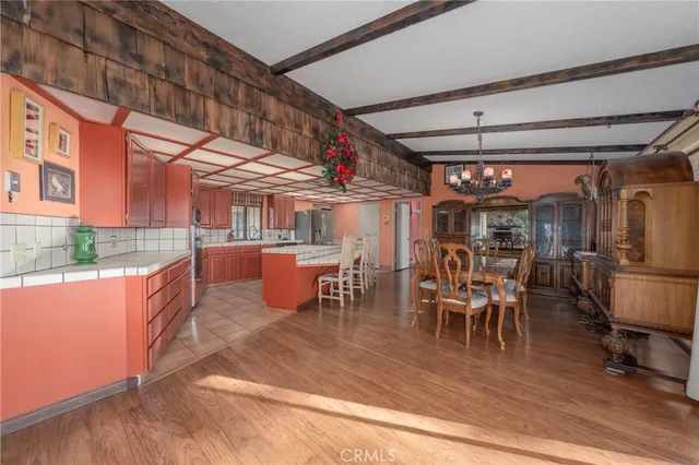 a room with granite countertop lots of wooden cabinets and stainless steel appliances