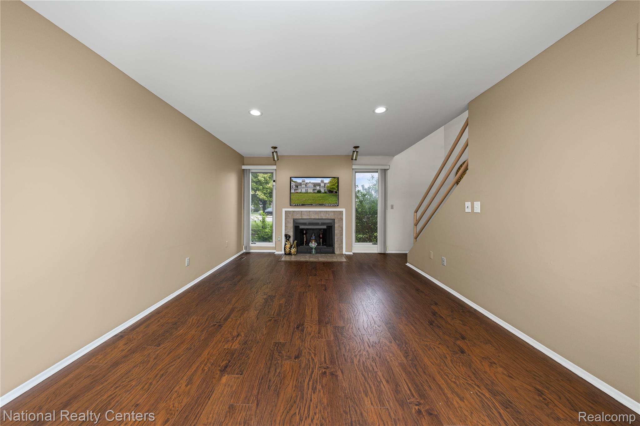 5274 East 14 Mile Road Warren, MI 48092 - Photo 6 of 31 Spacious living area featuring wood-finish flooring, recessed lighting, and a fireplace with a light-colored surround