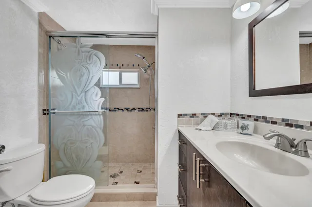 a bathroom with a sink toilet and shower