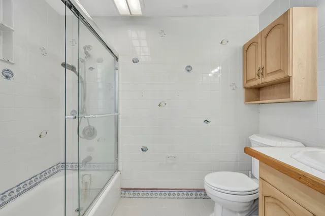 a bathroom with a granite countertop toilet a sink and shower