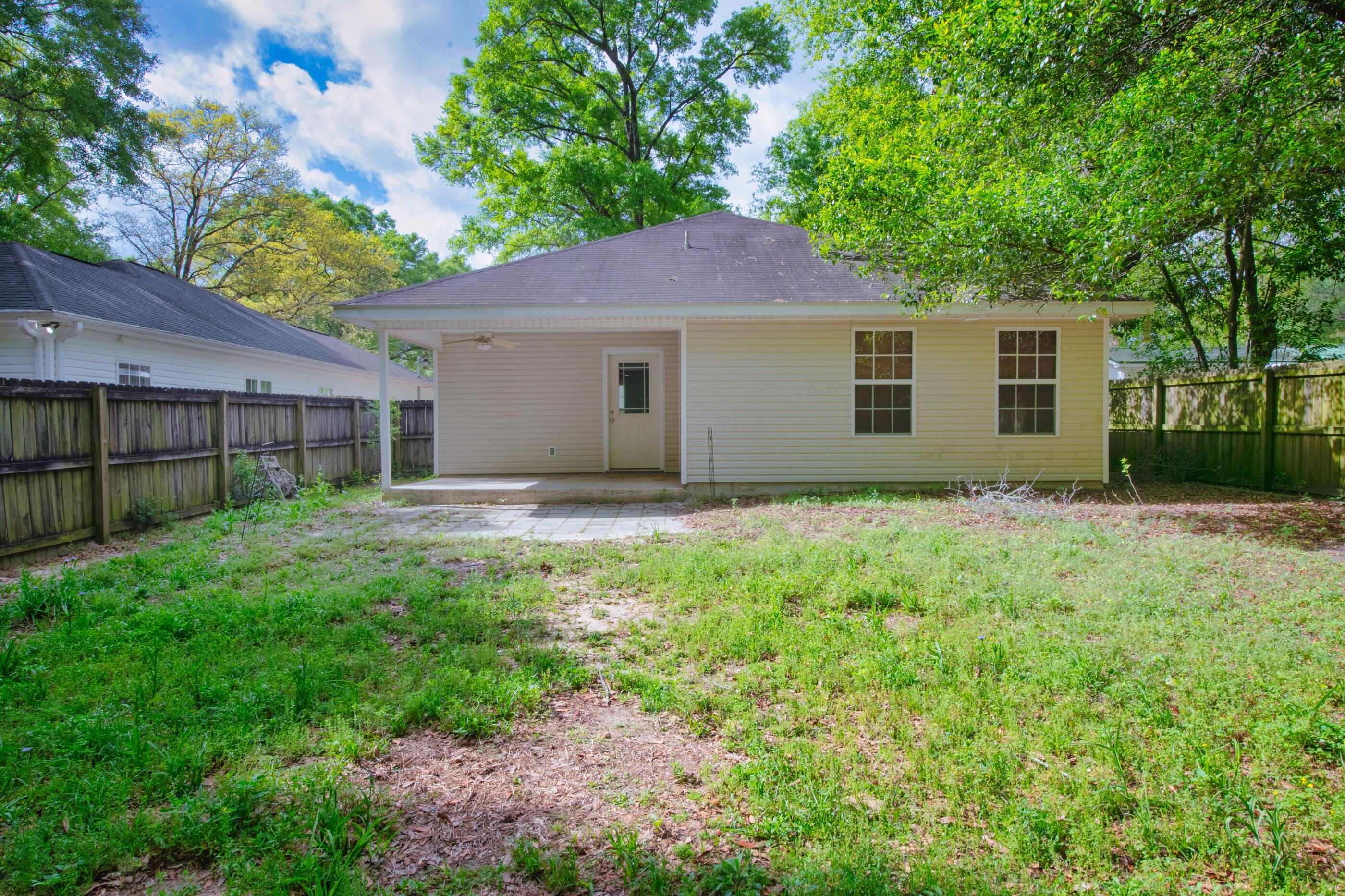 706 Brock Avenue Crestview, FL 32539 - Photo 17 of 18 a backyard of a house with large trees and plants