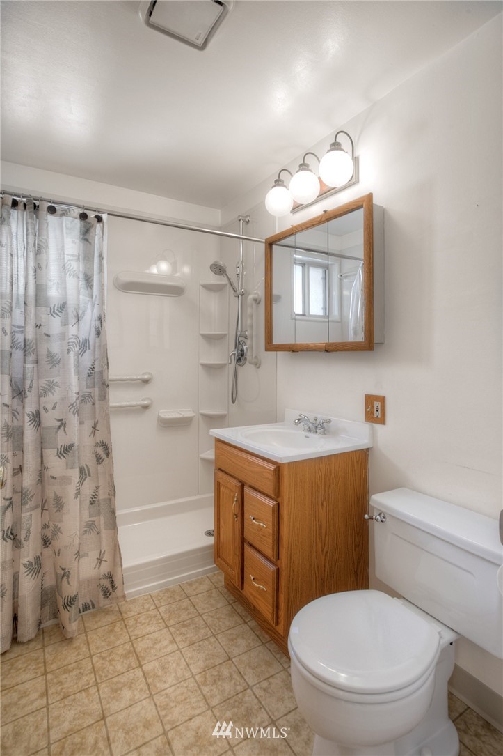 619 Southwest Normandy Road Normandy Park, WA 98166 - Photo 11 of 24 a bathroom with a toilet a sink and a mirror