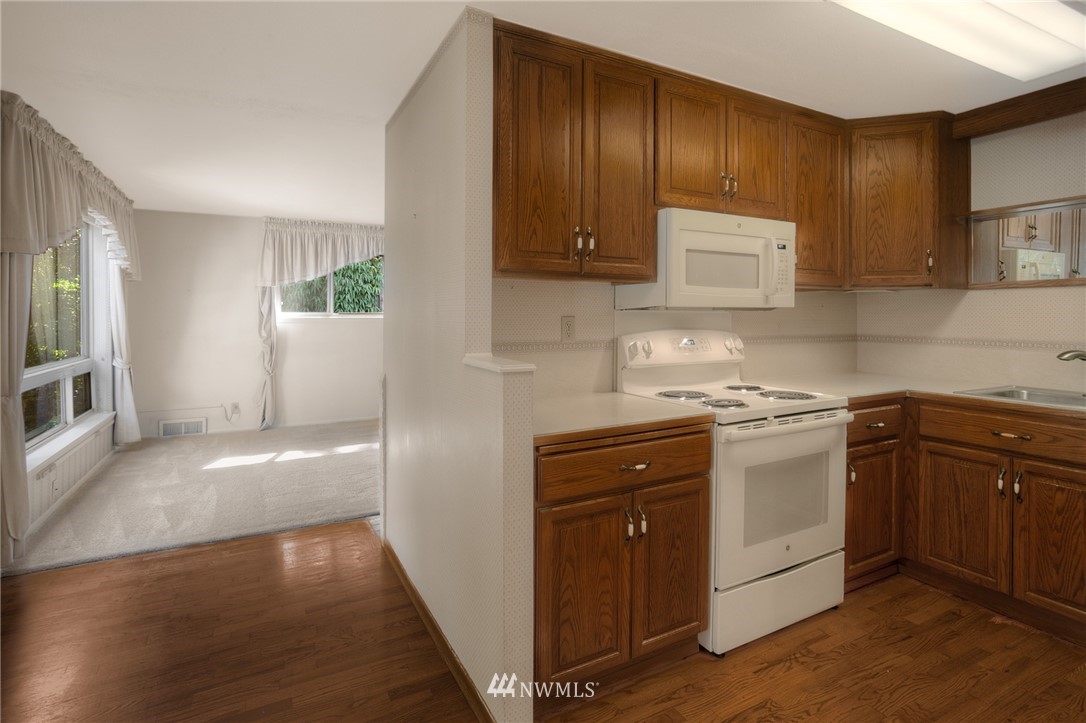 619 Southwest Normandy Road Normandy Park, WA 98166 - Photo 5 of 24 a kitchen with granite countertop wooden cabinets and white appliances