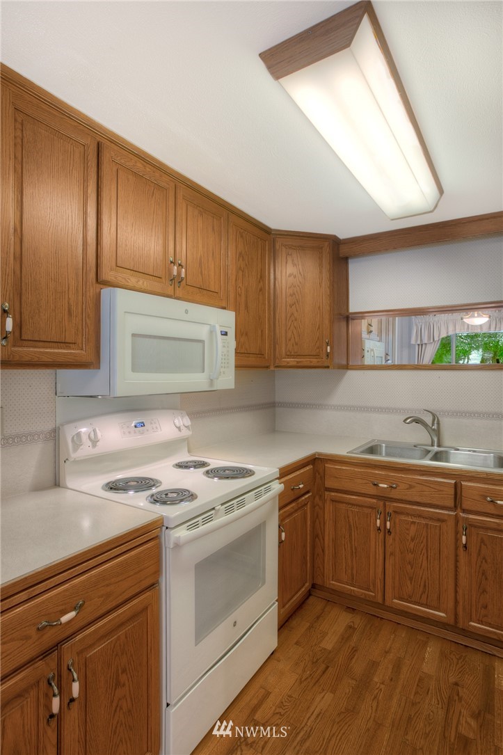 619 Southwest Normandy Road Normandy Park, WA 98166 - Photo 7 of 24 a kitchen with a sink stove and cabinets