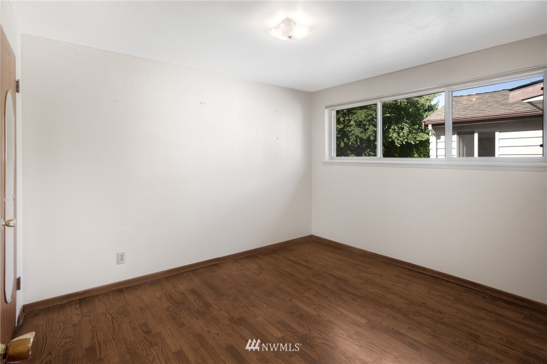 619 Southwest Normandy Road Normandy Park, WA 98166 - Photo 10 of 24 an empty room with wooden floor and windows