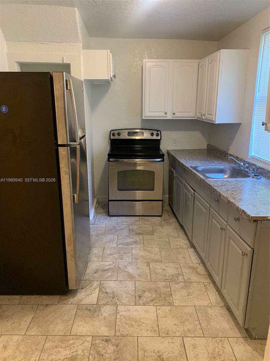 1129 Grothe Street Jacksonville, FL 32209 - Photo 12 of 21 a kitchen with granite countertop a refrigerator and a stove