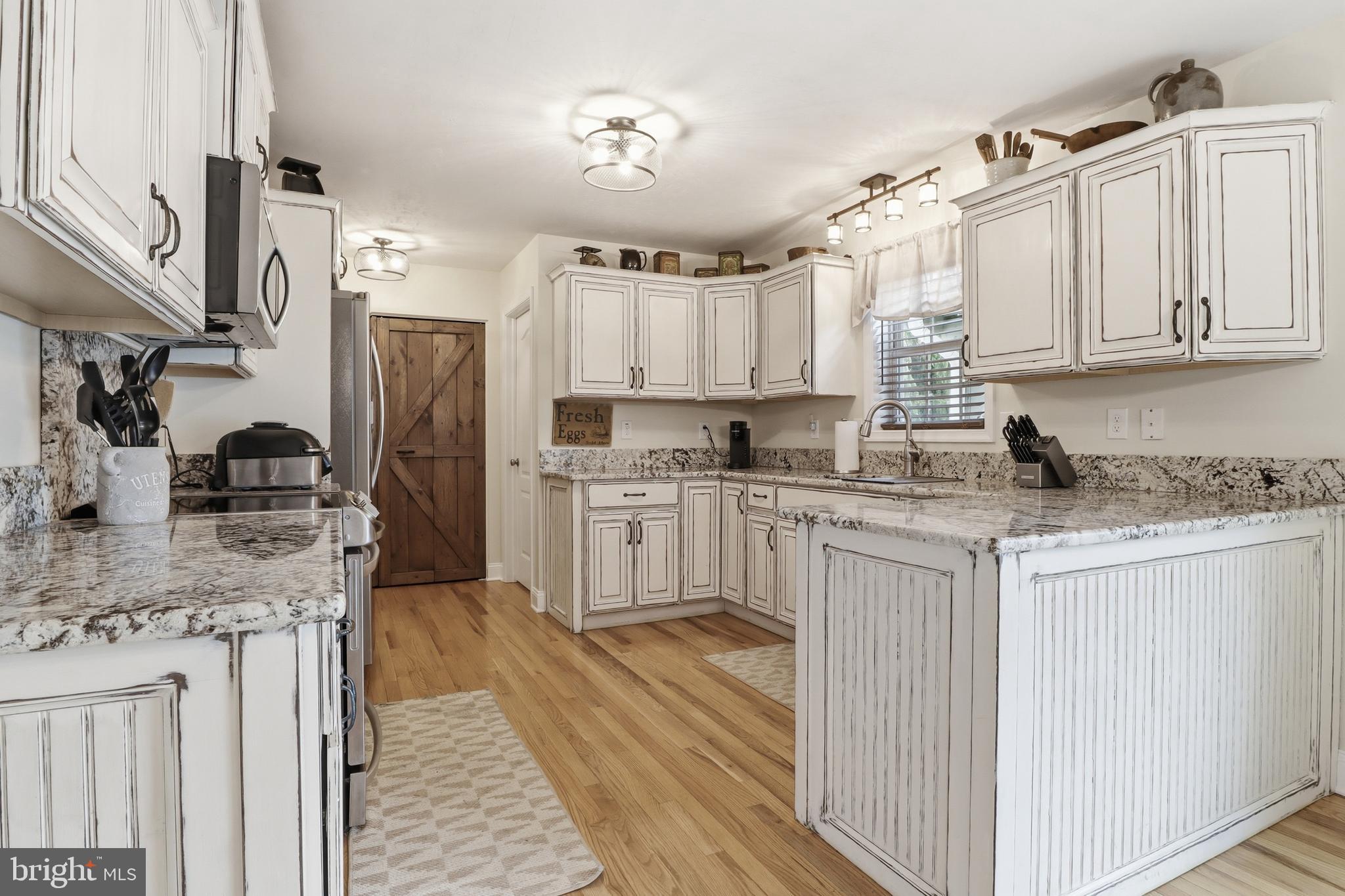 6083 Jennifer Lane Spring Grove, PA 17362 - Photo 12 of 61 a kitchen with stainless steel appliances granite countertop a stove a sink dishwasher a refrigerator white cabinets and wooden floor