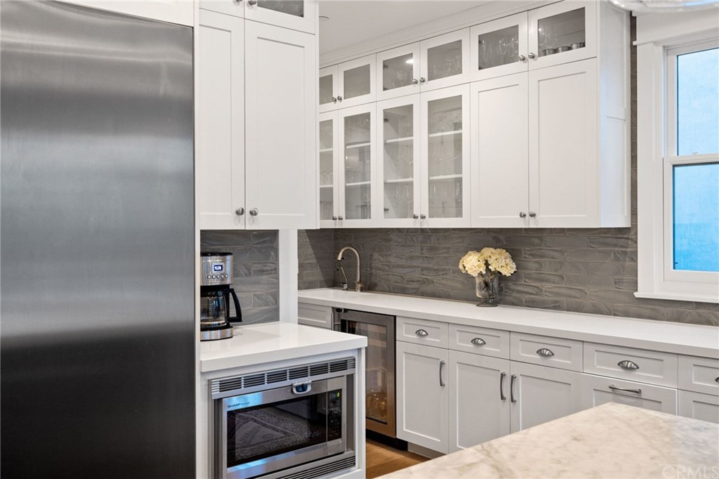 1120 6th Street Manhattan Beach, CA 90266 - Photo 15 of 64 a kitchen with granite countertop white cabinets and white appliances