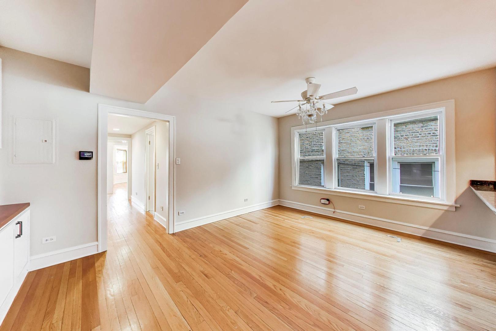 1734 West Foster Avenue, Unit 1 Chicago, IL 60640 - Photo 16 of 24 a view of an empty room with wooden floor and a window